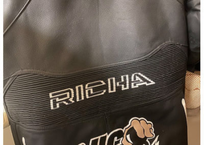 Couture d'un écusson, ou patch, sur combinaison de moto